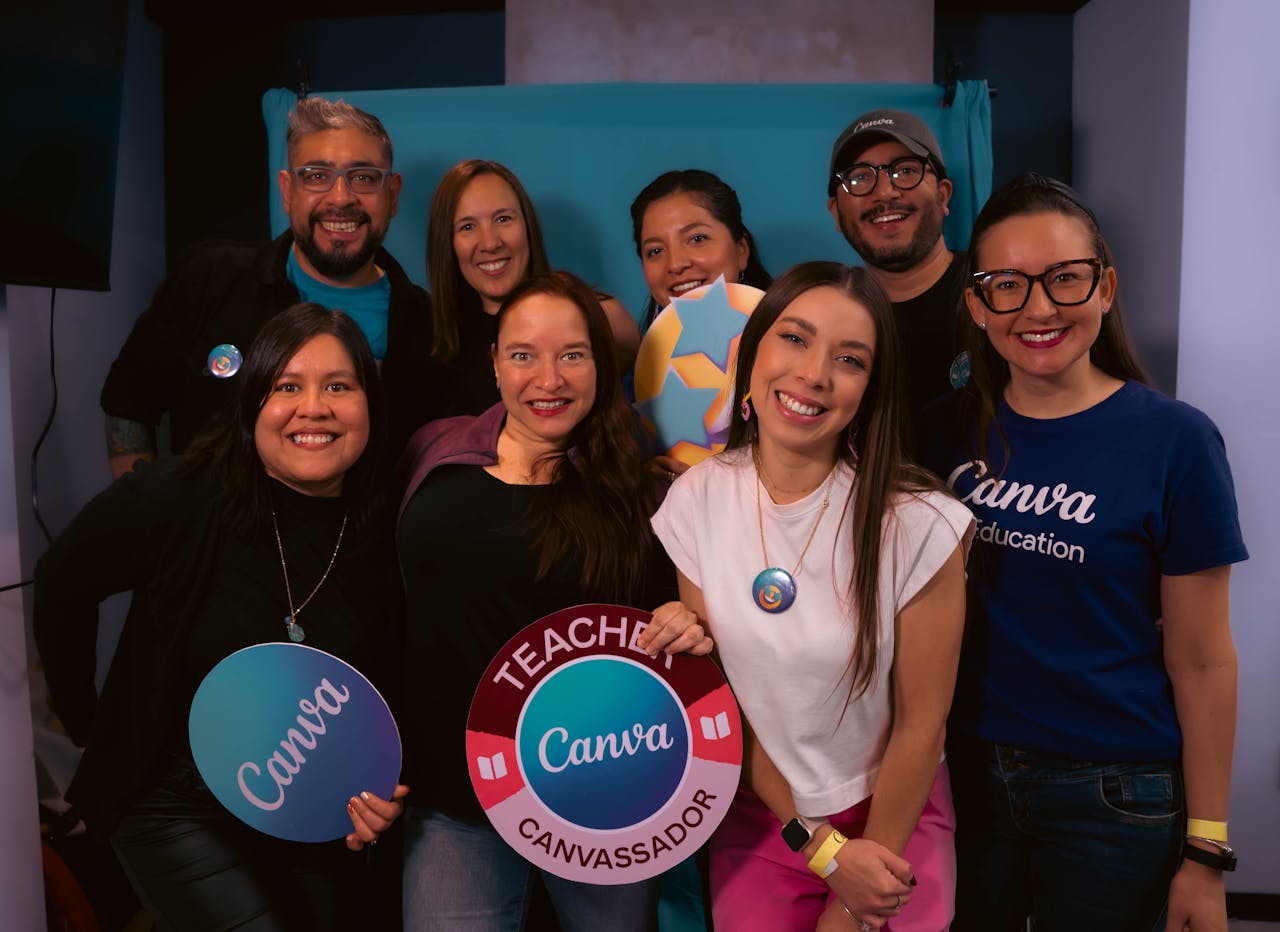 services-02 A lively group of teachers posing with Canva signs at an educational event.